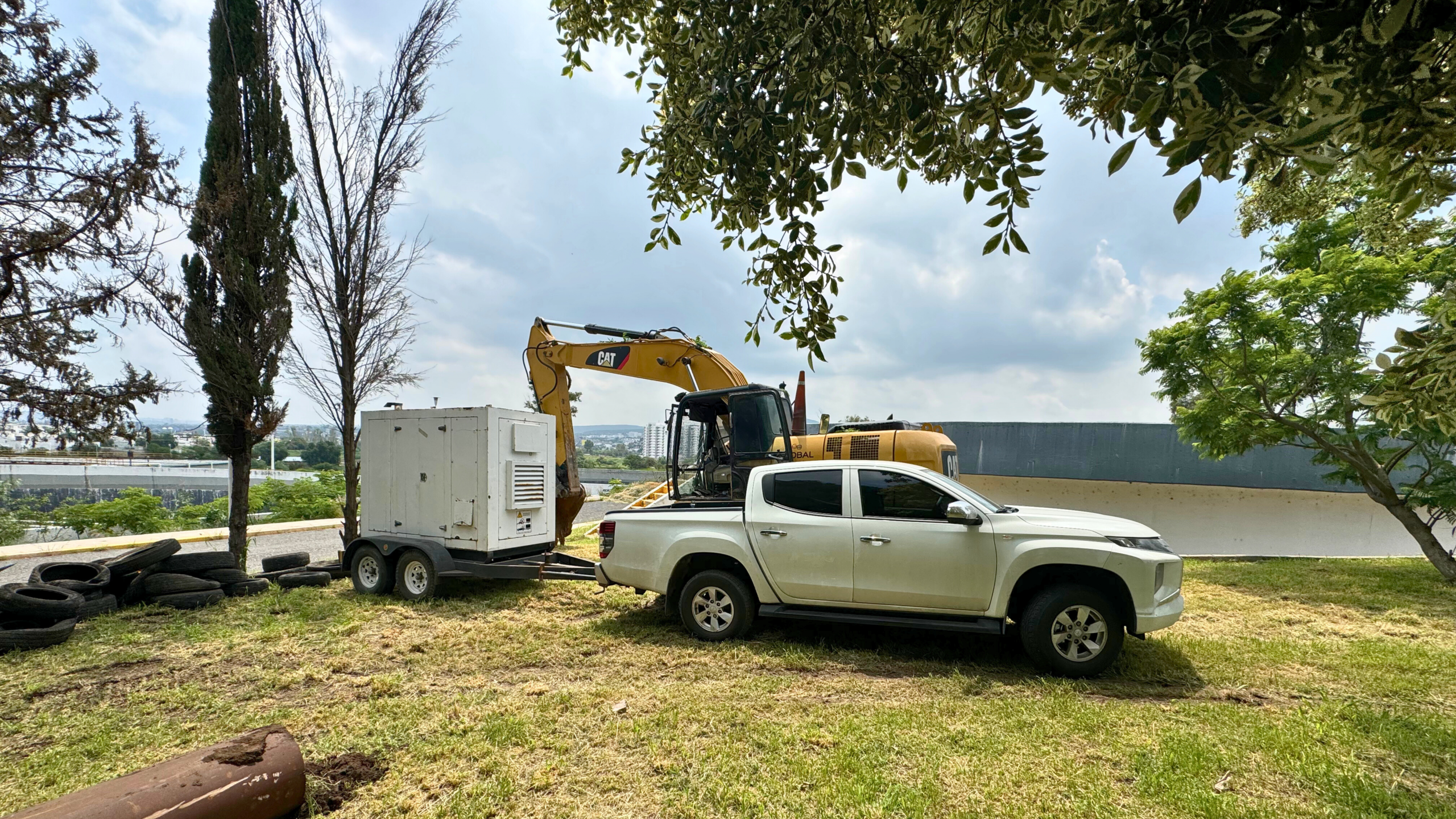 Camioneta Mitsubishi L200 junto a generadores y maquinaria en zona de obra industrial